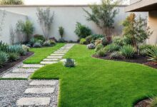 Área externa com grama artificial, arbustos e caminhos de cascalho em estilo minimalista.