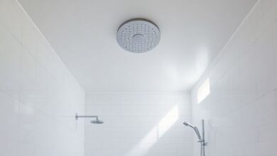 Banheiro sofisticado com chuveiro de teto cromado em ambiente minimalista.