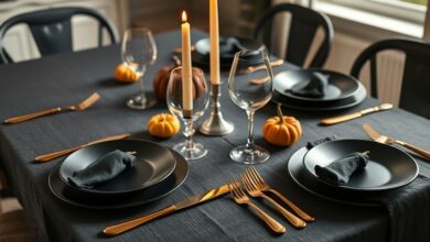 Mesa decorada com tema de Halloween usando velas pretas, abóboras e talheres dourados.